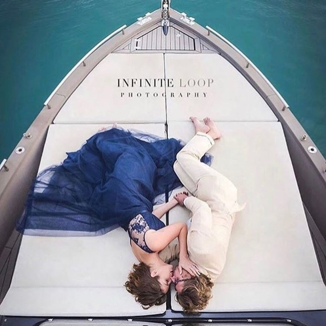 A couple posing on a boat during an engagement session