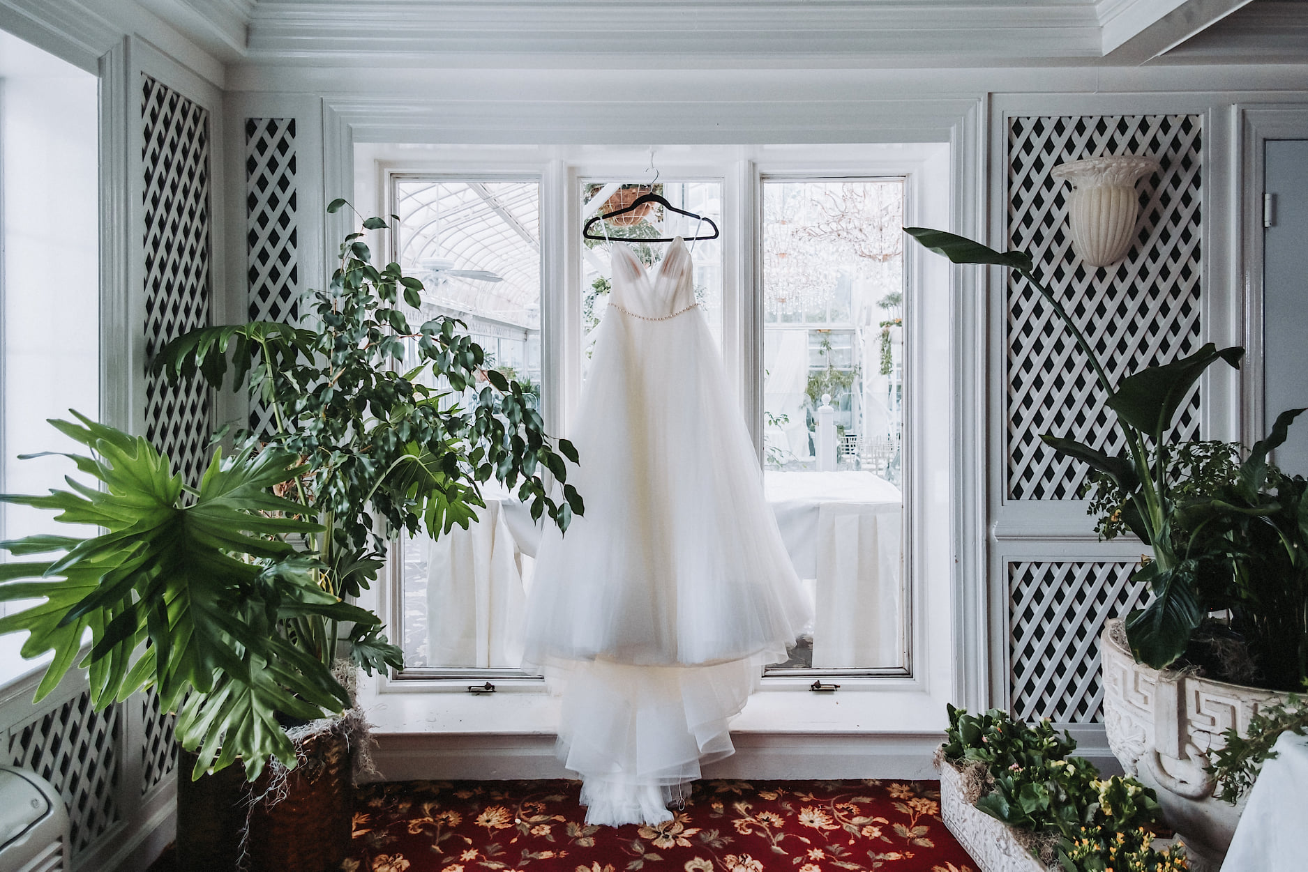 a bridal dress hanging from a window pane