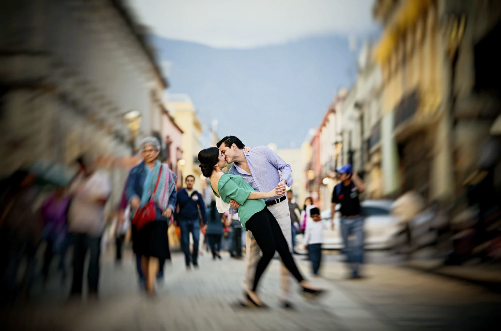 a couple kissing in the middle of a busy street