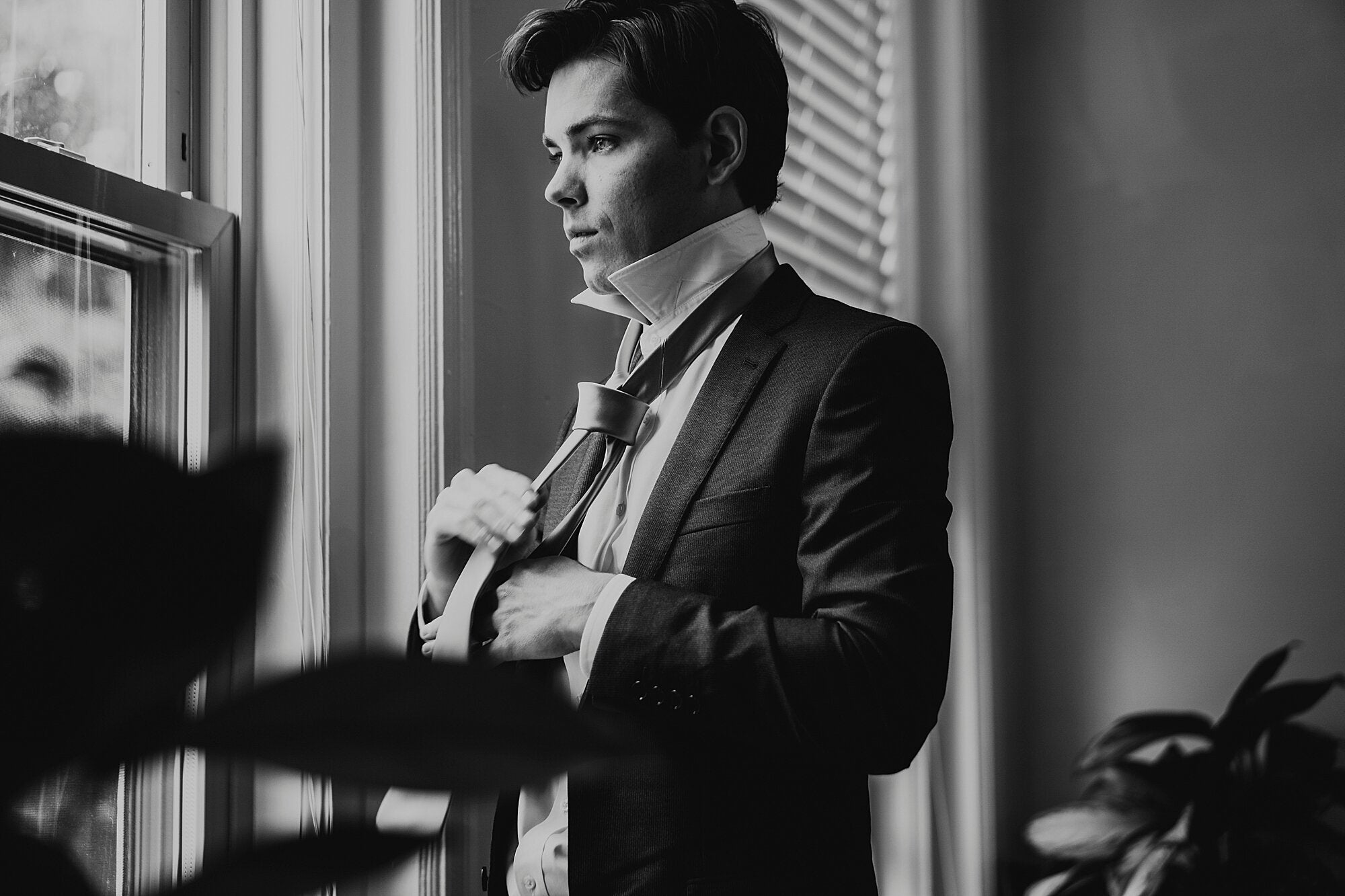 A bridegroom's side profile shot of wearing his tie