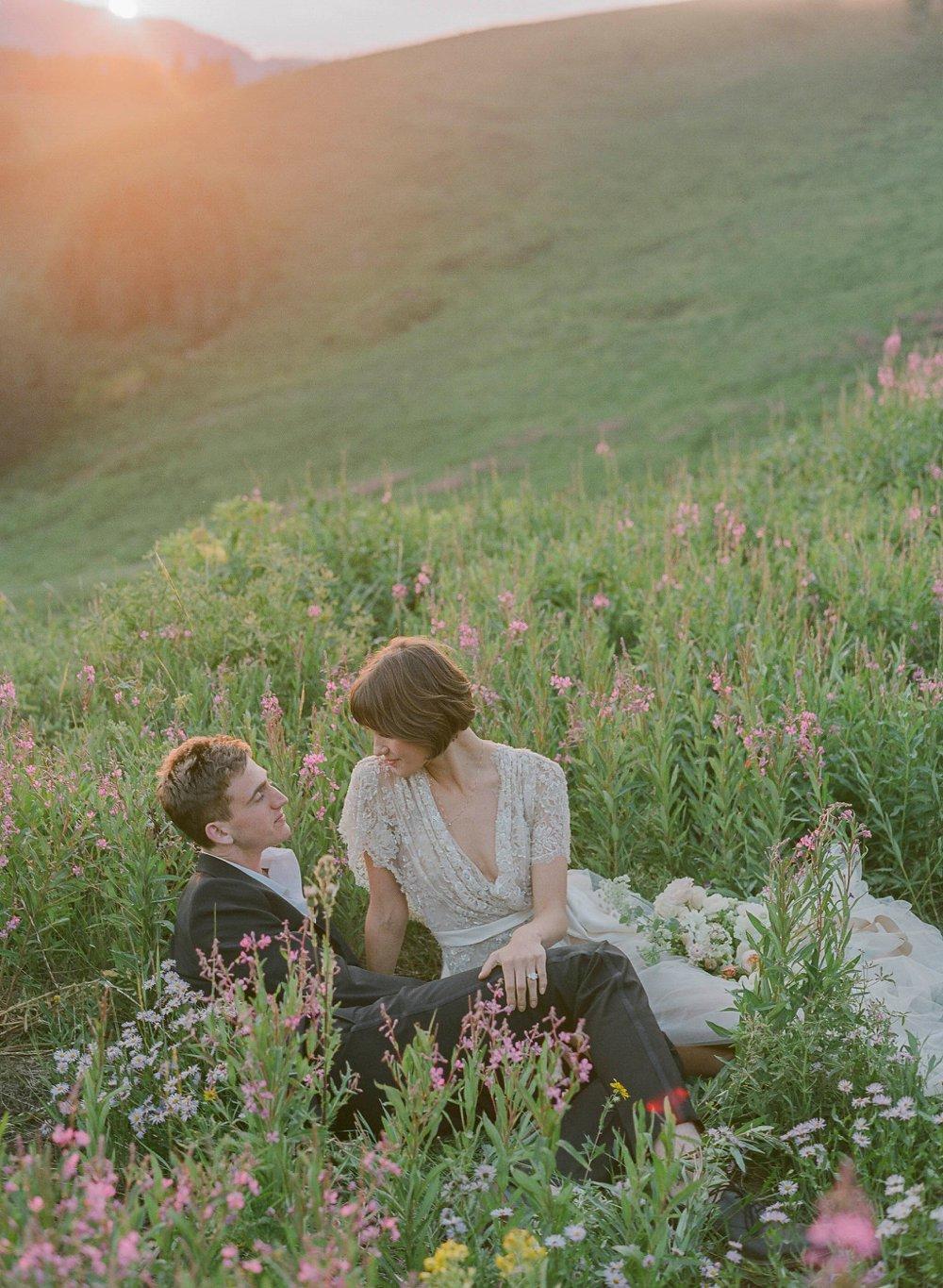 A cinematic shot featuring a couple surrounded by flowers and greenery - Laura Murray wedding photography metrics