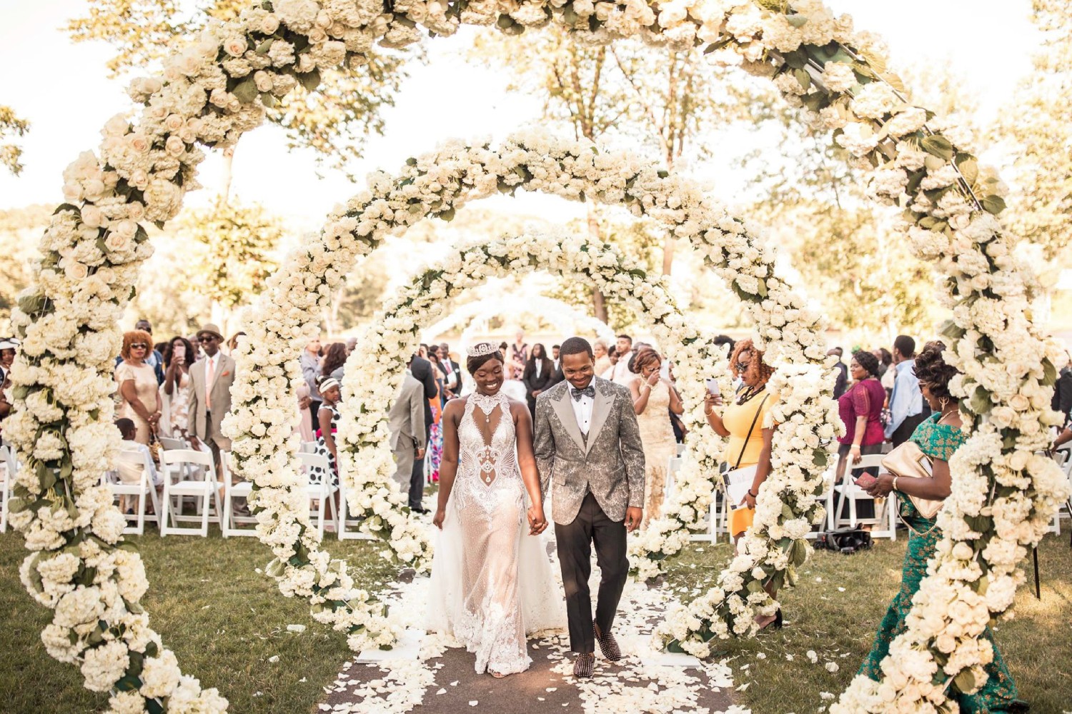 a newlywed couple exiting the wedding ceremony through a flower arrangement 