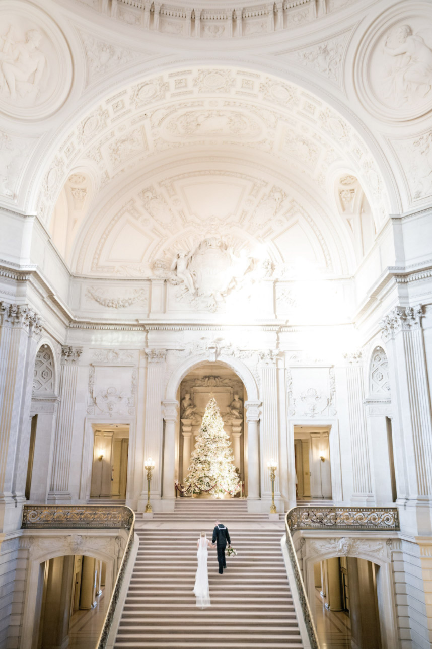 a wedding couple climbing the stairs of a grand church