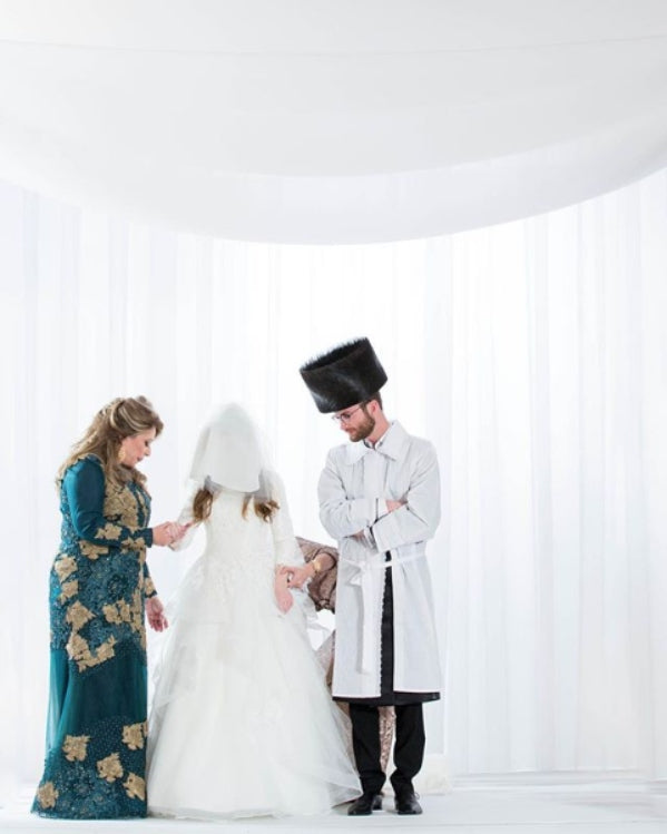 couple looking down at bride covered by veil