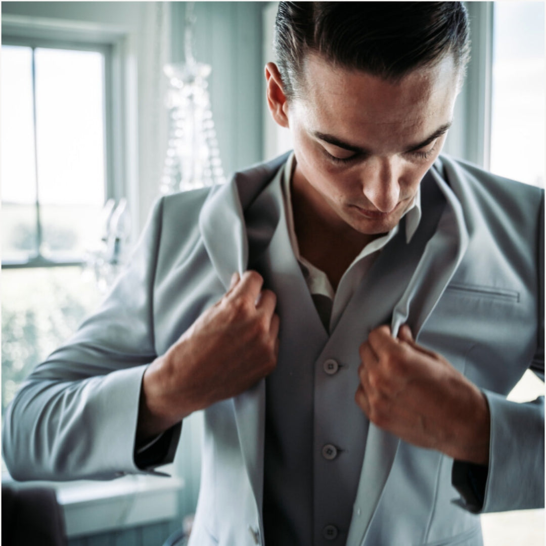 Groom getting ready wearing a blue blazer