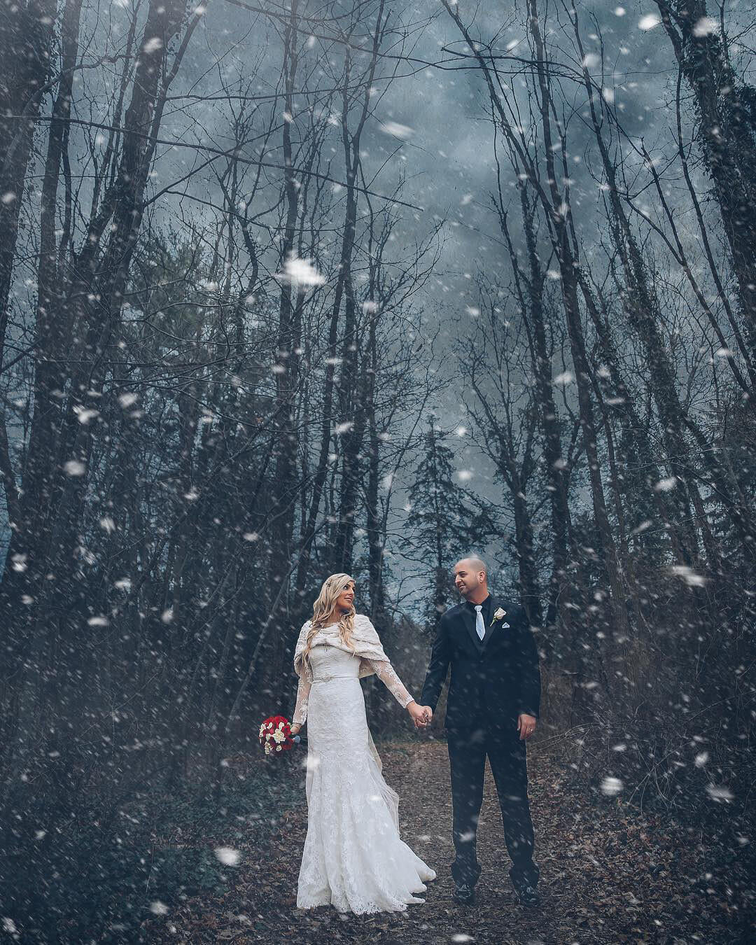 A winter wedding photoshoot of bride and groom walking hand-in-hand  during the snowfall