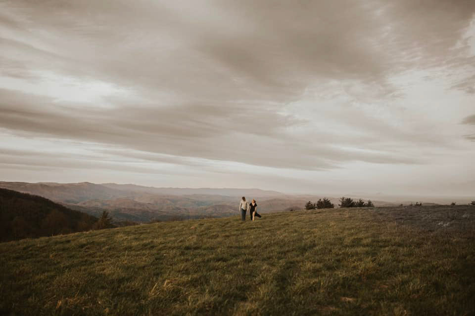 a wedding couple in the far away distance of a beautiful hilly landscape