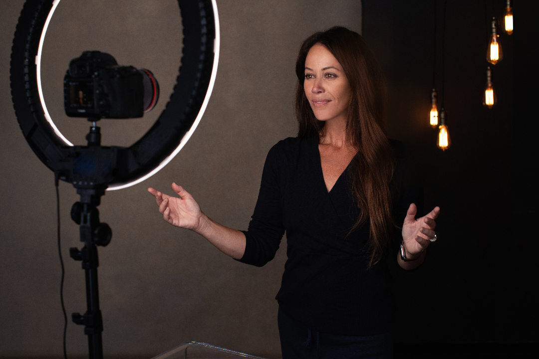 A person standing in front of the camera and lights as the recording goes on