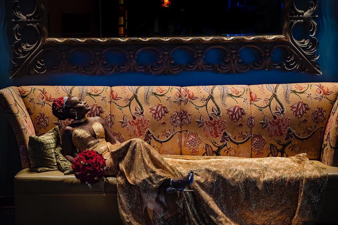 A bride posing while sitting on a large couch