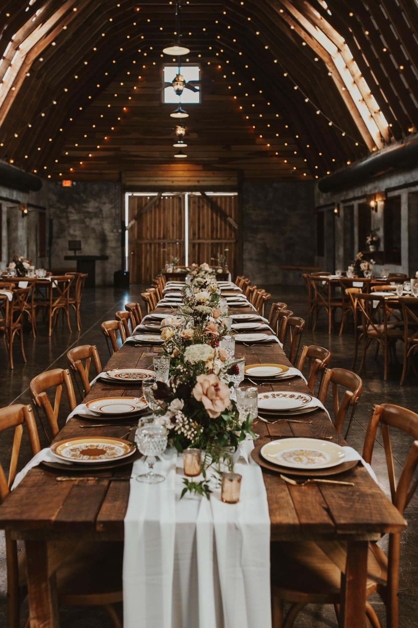 a wedding reception table with plates and floral decorations