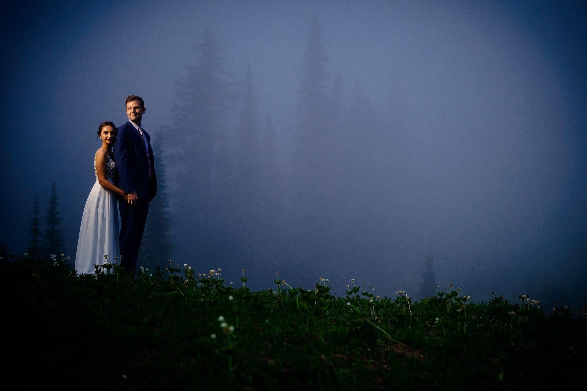 Bride standing behind the groom to pose for a photo 