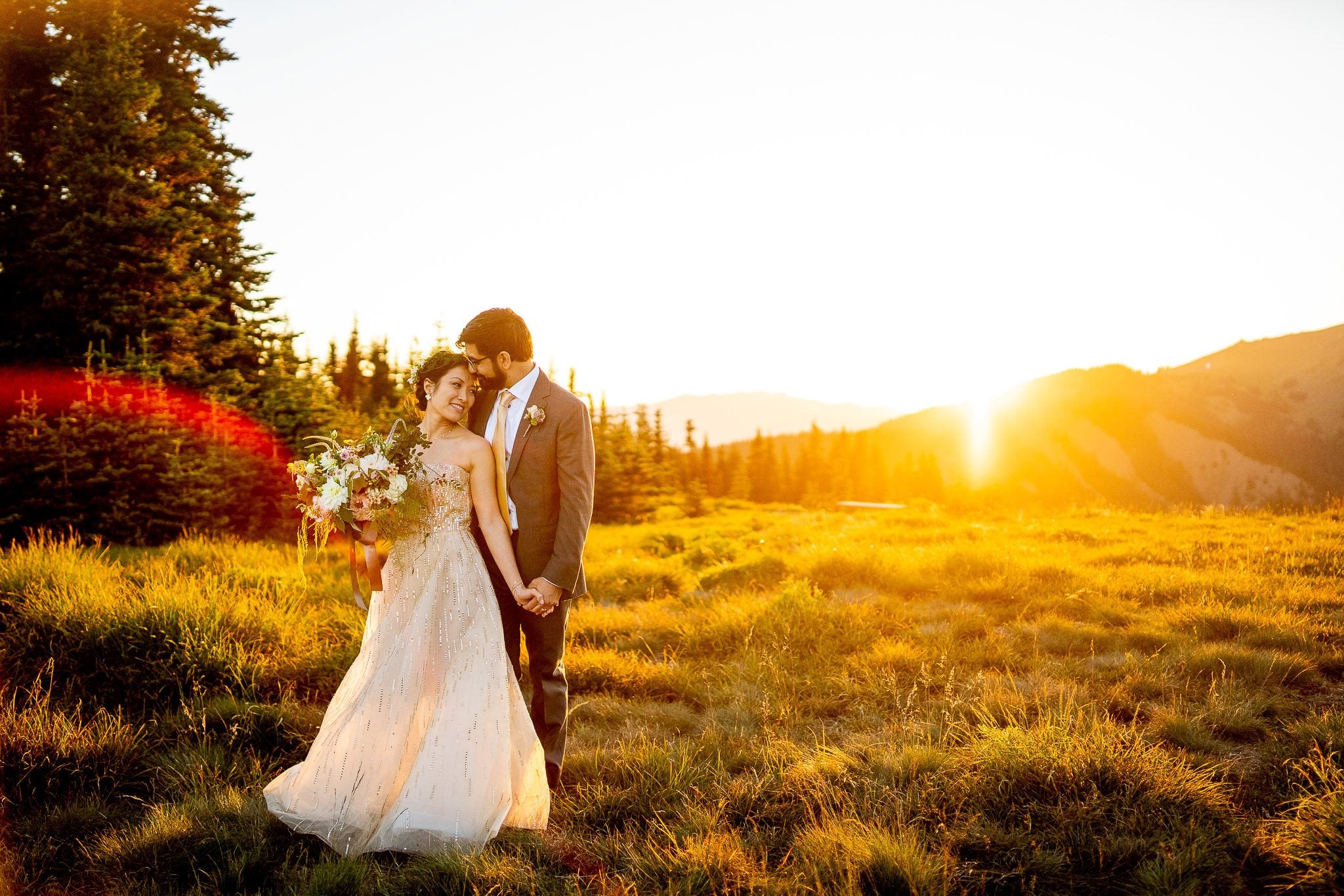 Groom holding the bride’s hand while gently kissing her forehead