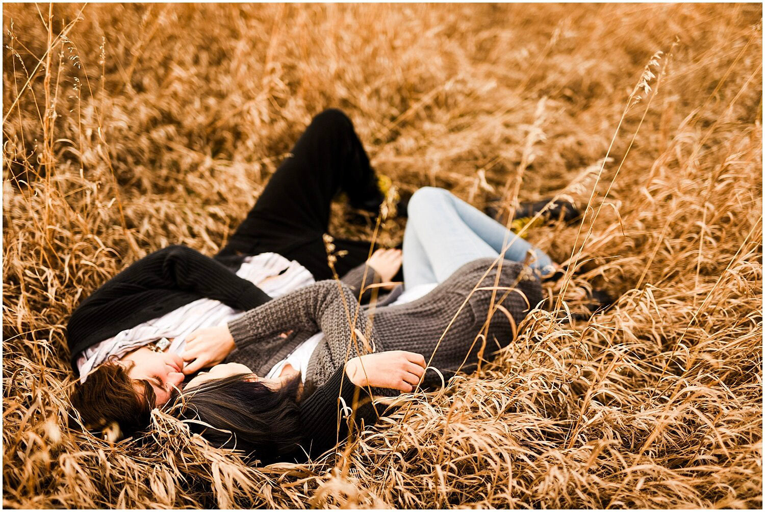 a wedding couple sharing an affectionate moment lying down on the grass