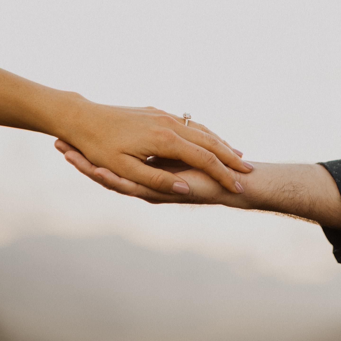 Close up shot of a couple's hand placed over each other