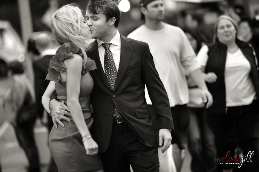 A black and white photo of a couple kissing during their engagement session in New York City on a crosswalk.