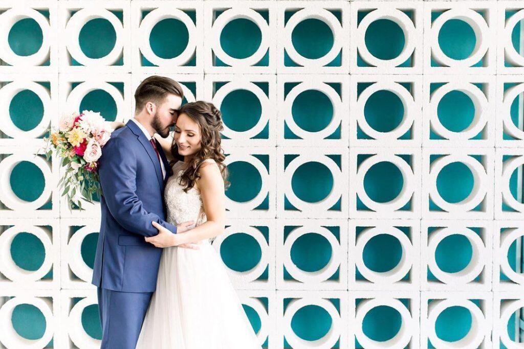 a couple embracing each other in front modern designed wall