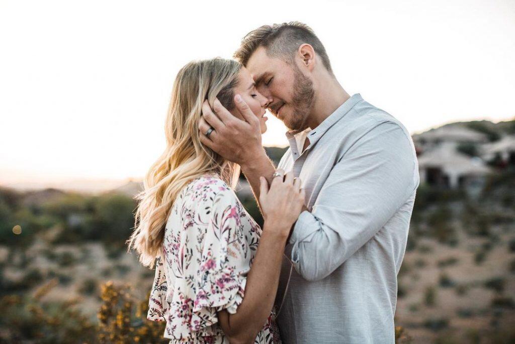 a bride and a groom embracing each other on a rocky terrain