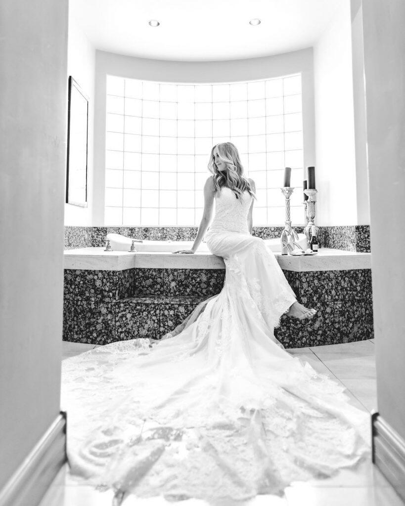 a bride posing sitting on an elegant bathtub 