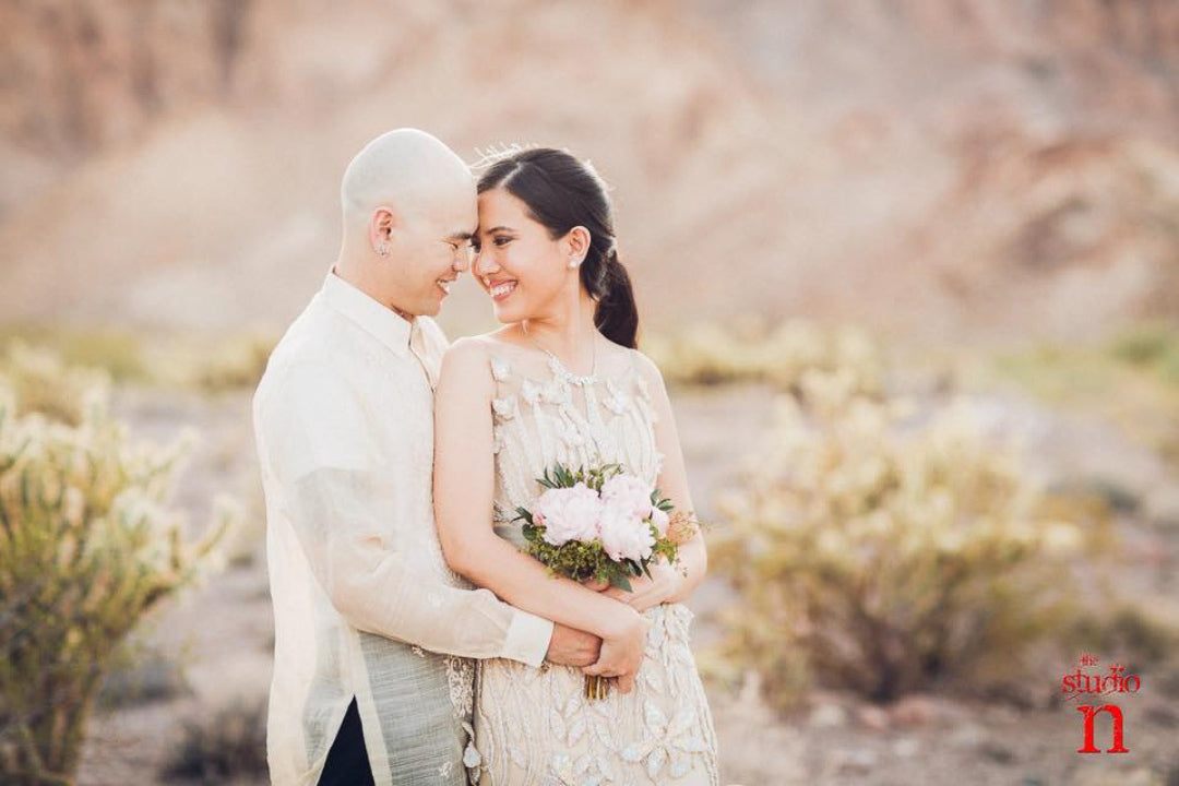 Bride and groom holding and facing each other while posing