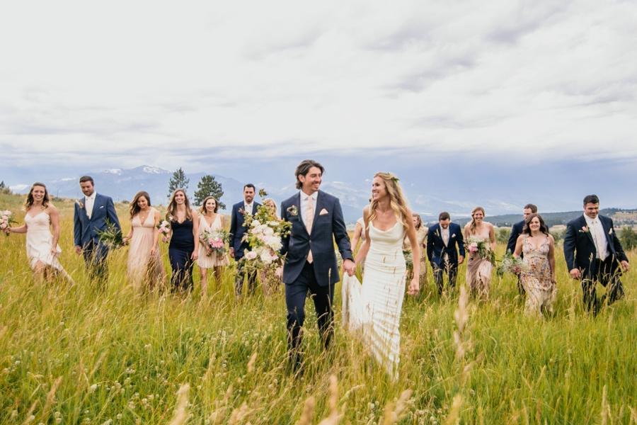 Bridesmaids and groomsmen walking alongside the bride and groom on a farm