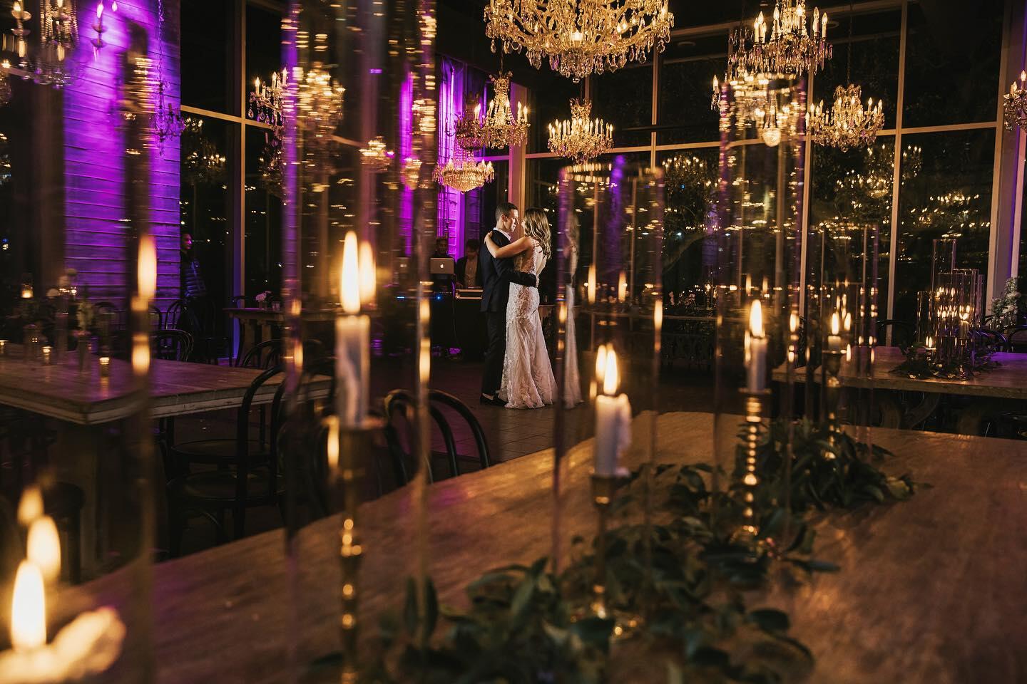 couple dancing on dance floor under chandeliers with city view