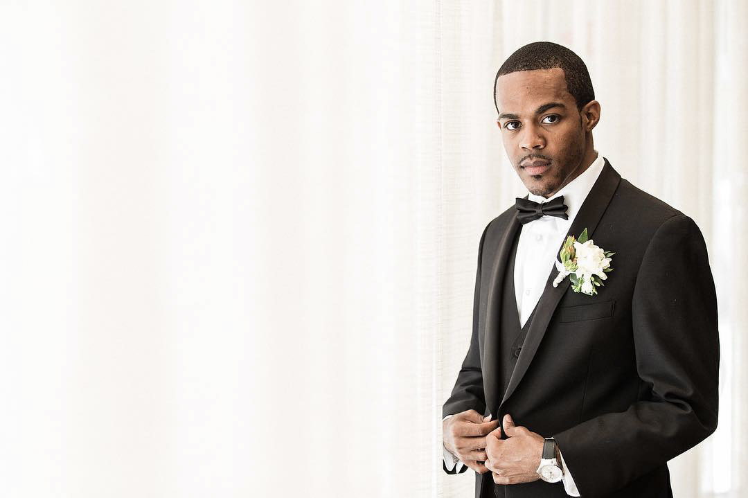 a wedding groom posing looking at the camera