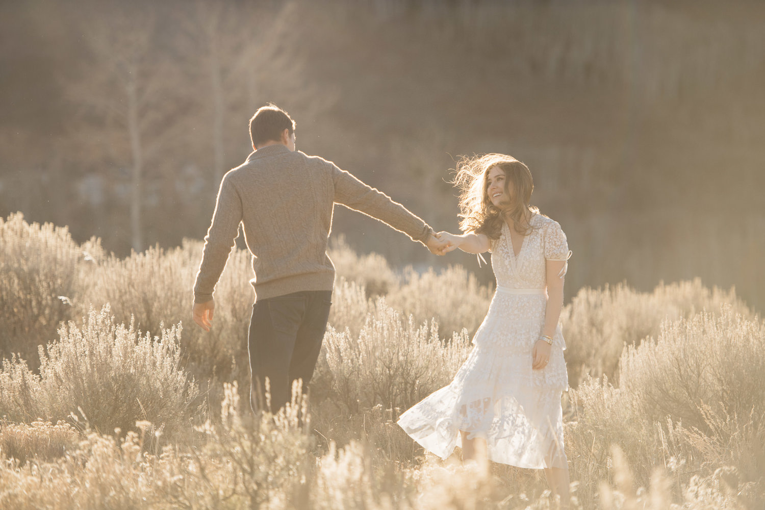 A couple holding hands at a field