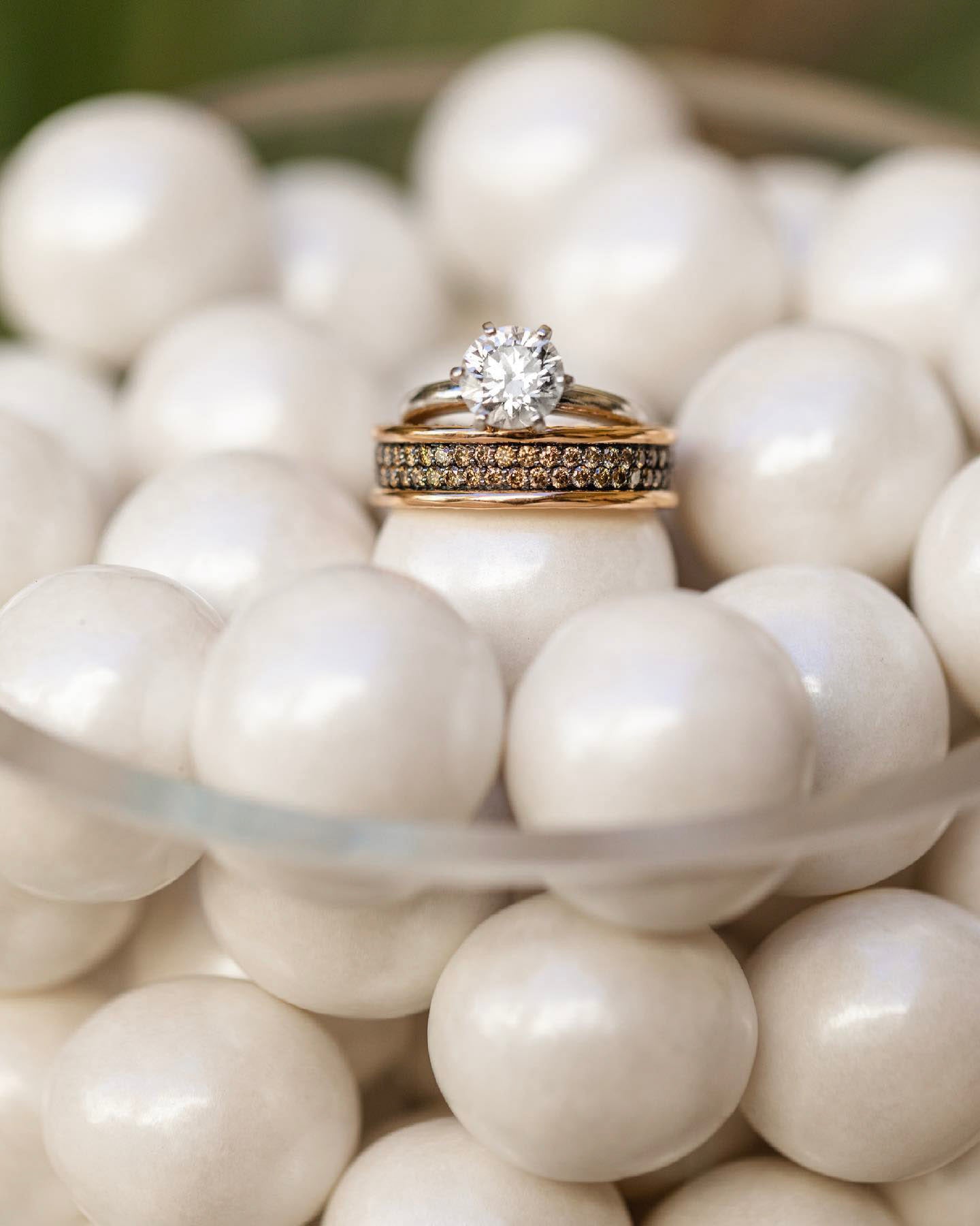 a pair of wedding rings on a bowl full of pearls