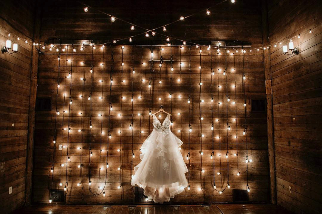 a bridal wedding dress on display with several little lights in the background