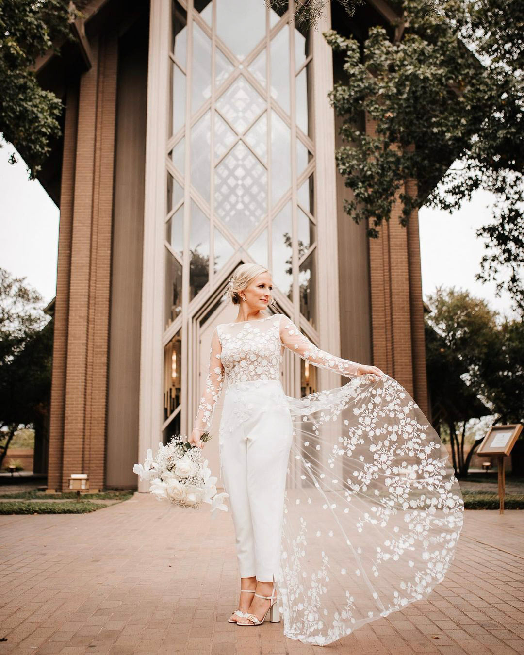 a bride posing with her wedding bouquet in her bridal dress