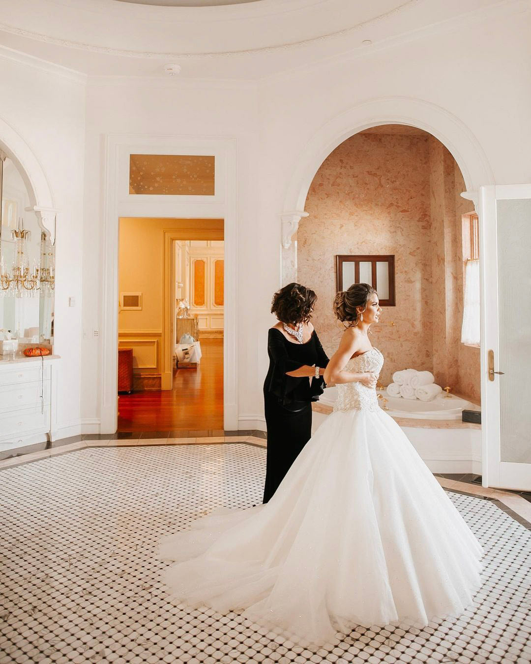 the mother of the bride is helping the bride dress for her wedding 