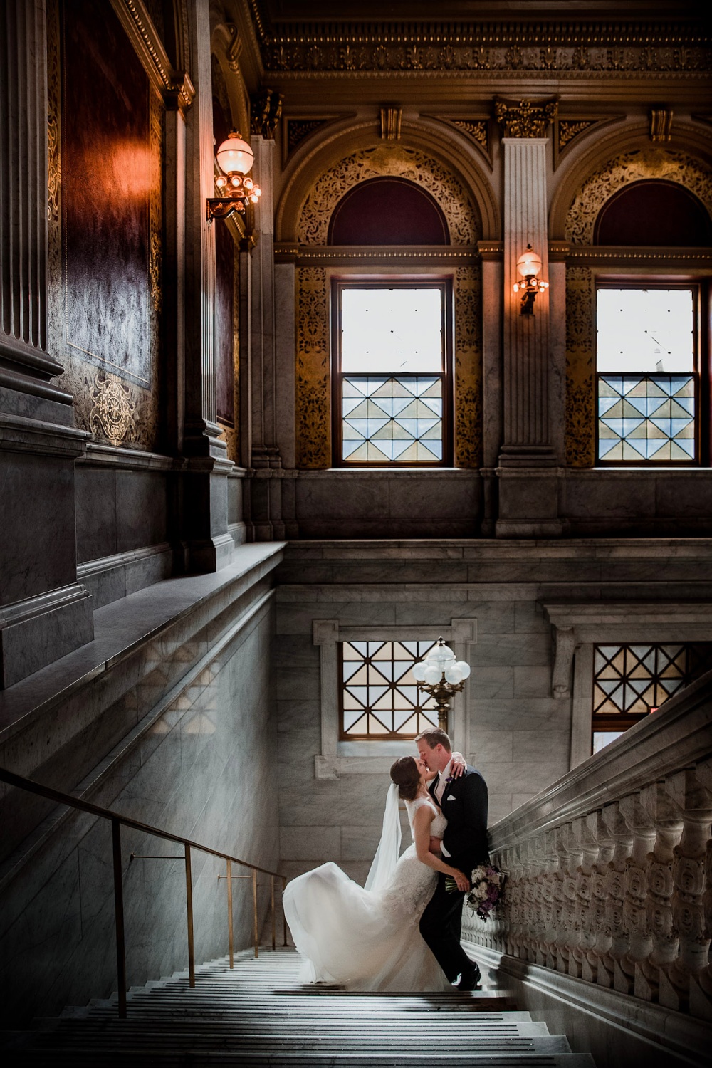 a bride and the groom kissing on a grand stairwell (Wedding moments captured that will leave you speechless)