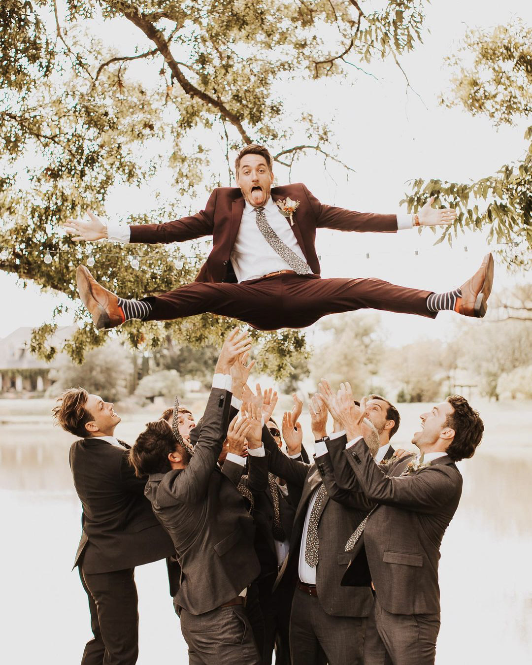 an image of the groomsmen tossing the groom