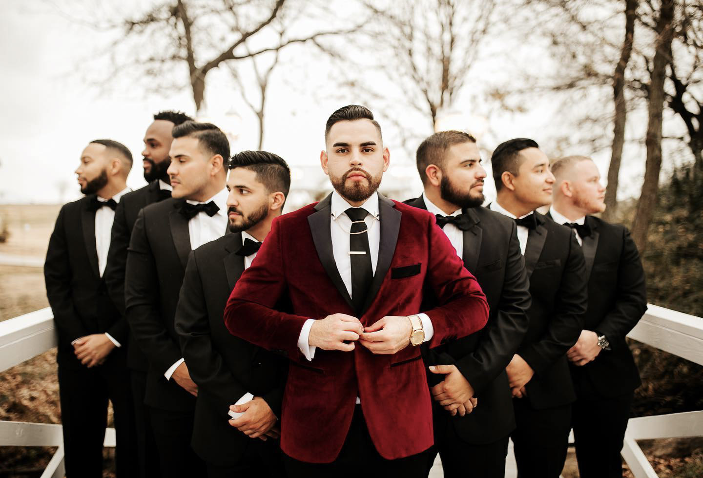 the grooms and the groomsmen posing in their wedding attire