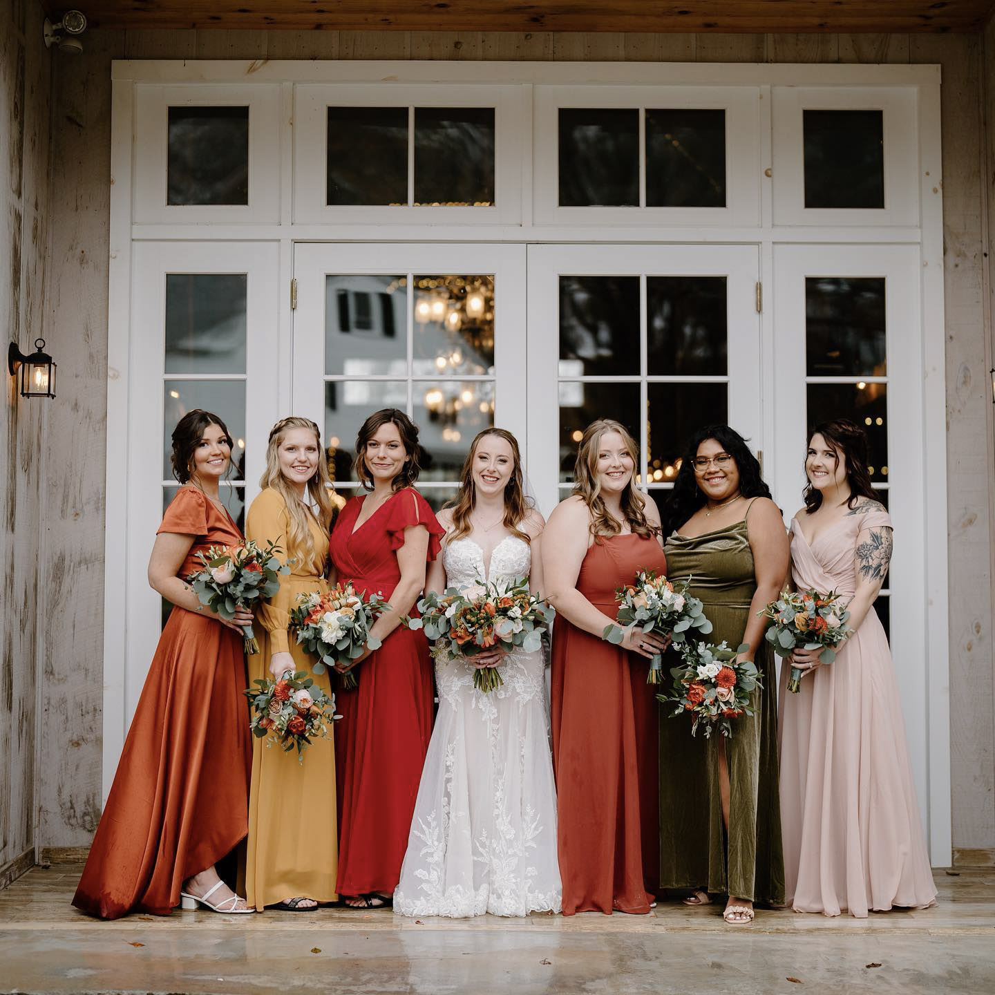 the bride and the bridesmaids posing with bouquets