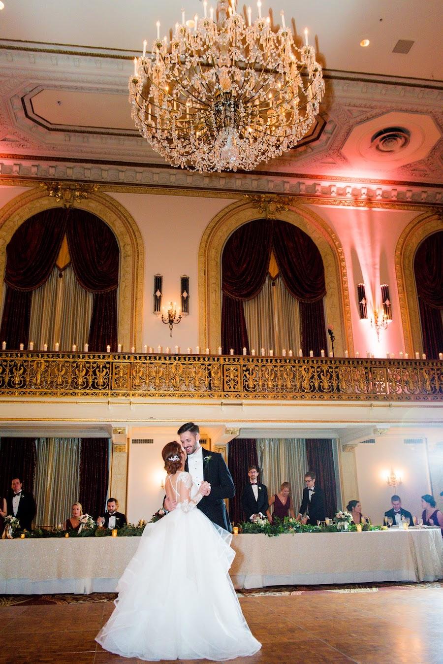 A bride and groom dancing under the chandelier