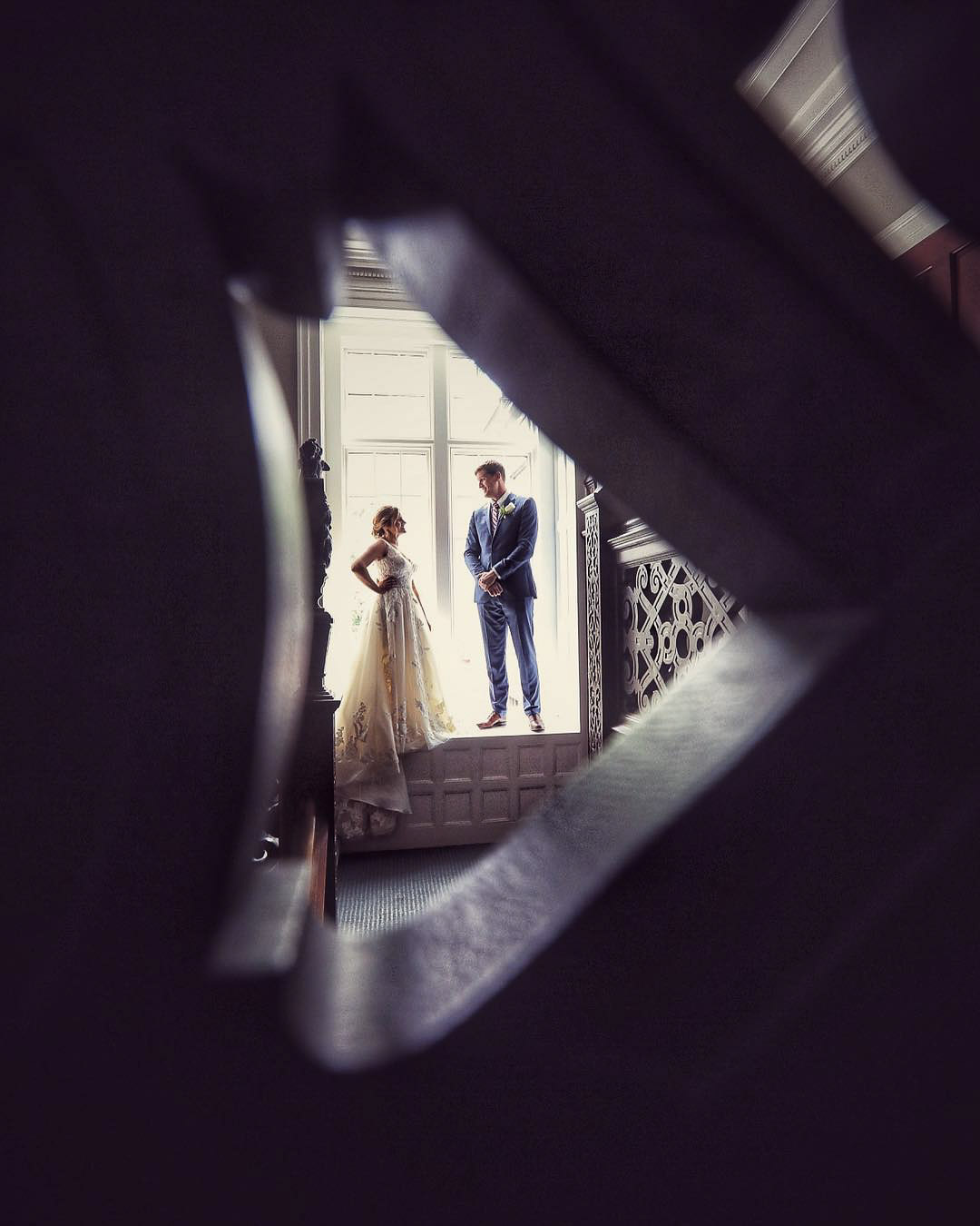 an image of the bride and groom through a textured hole