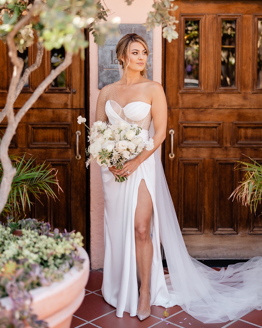 a wedding bride posing with the bouquet in her hand 