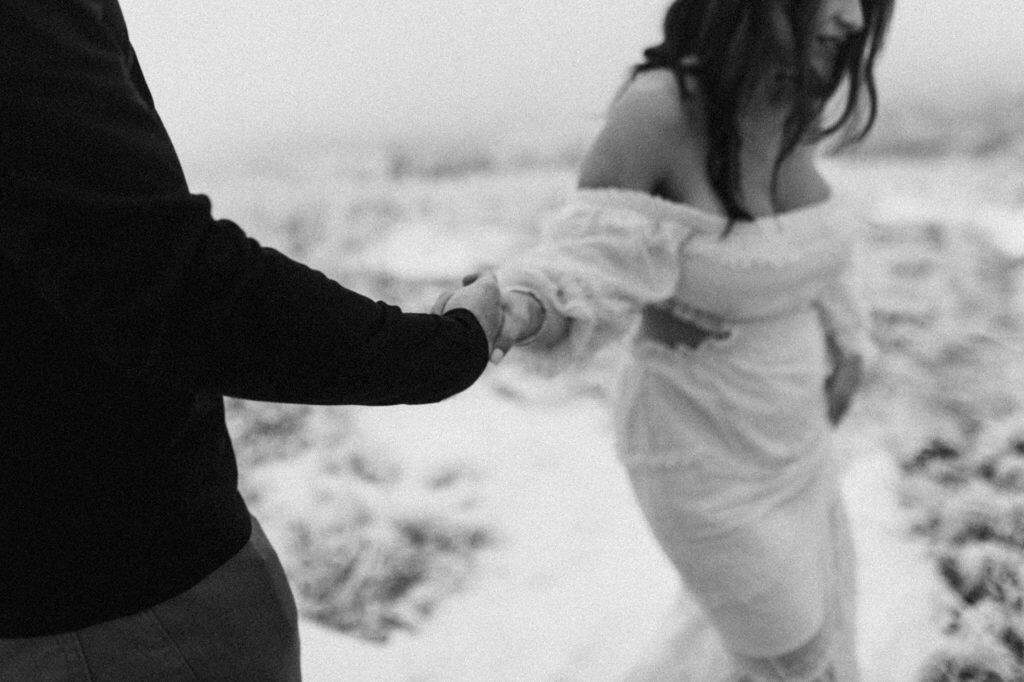 a bride in wedding attire holding the hand of the groom