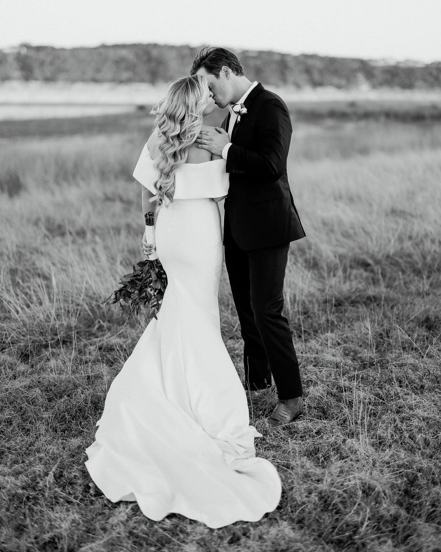 a wedding couple kissing standing on a meadow